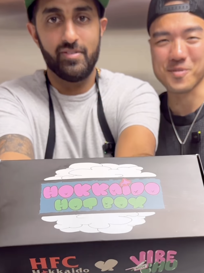 two men holding a promotional box