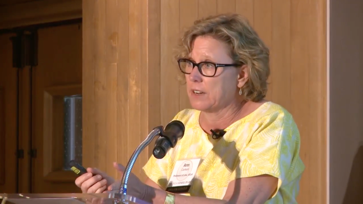 a woman speaks from a podium