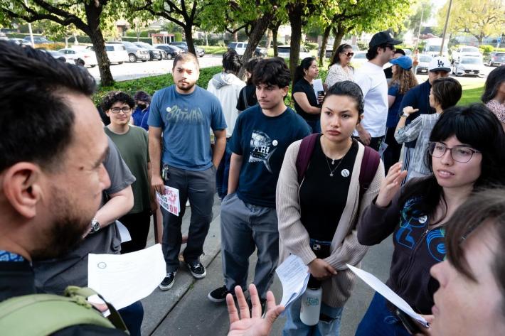 a crowd of people watching a man as he speaks