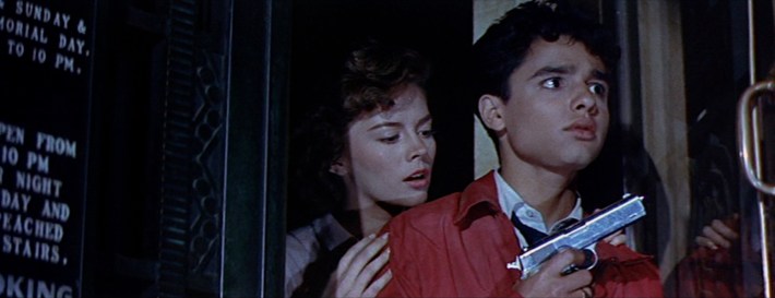 a girl behind a boy holding a gun