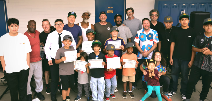 students holding certificates while posing with teachers and adults