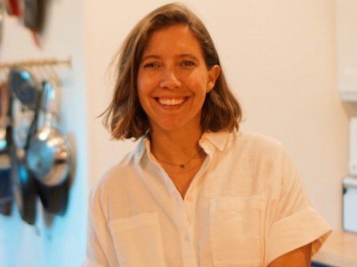 a woman smiles in a button up
