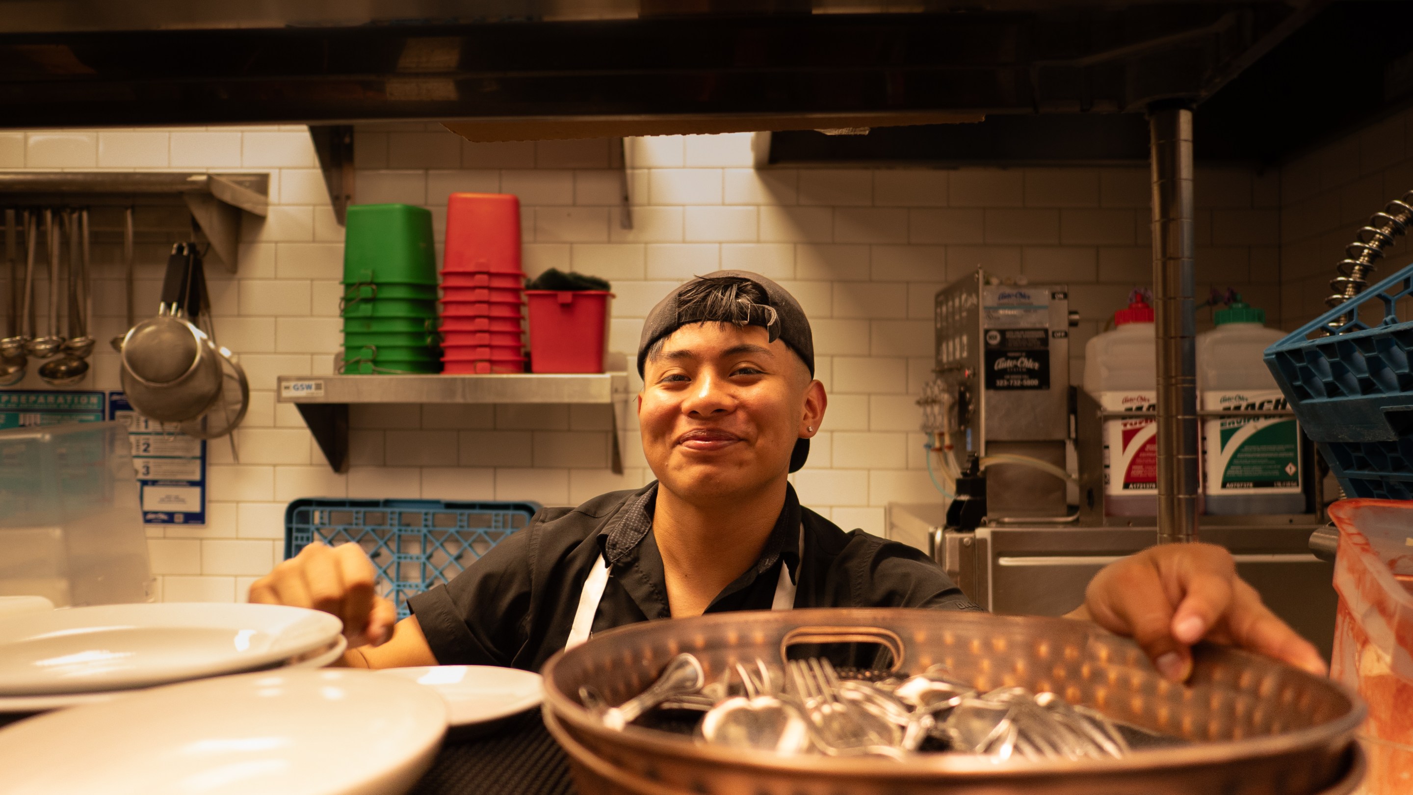 a man smiles from inside a restaurant kitchen