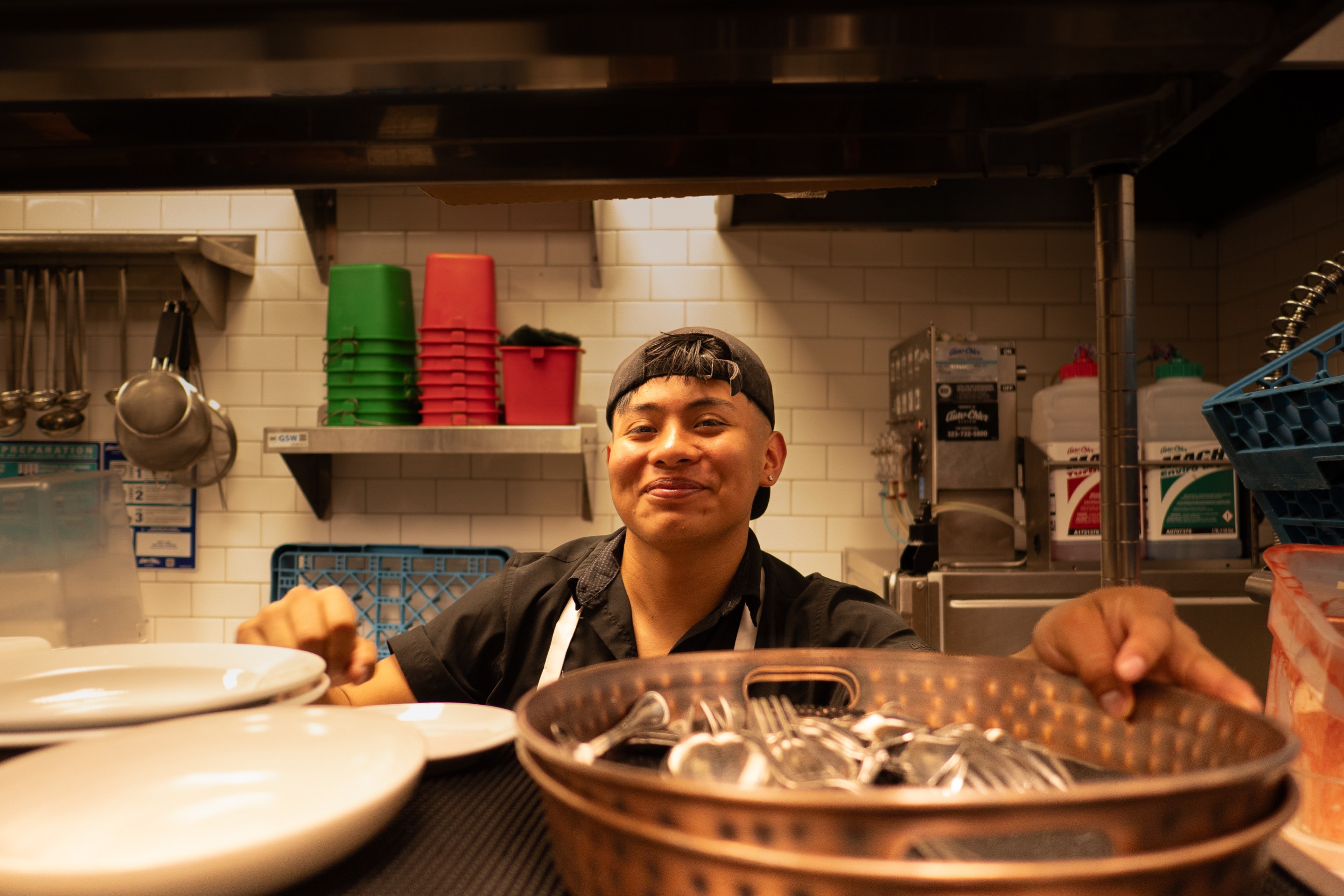 a man smiles from inside a restaurant kitchen