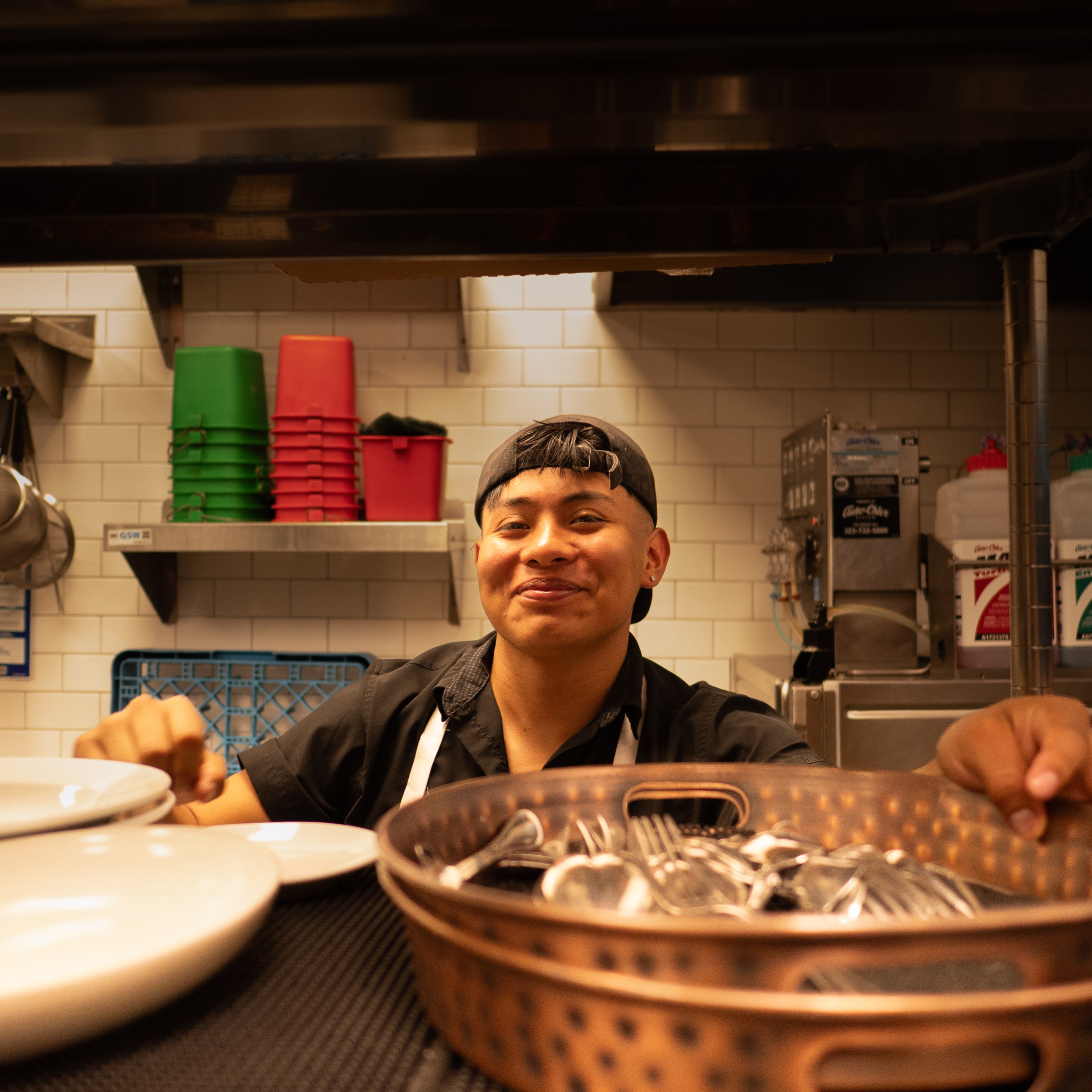 a man smiles from inside a restaurant kitchen