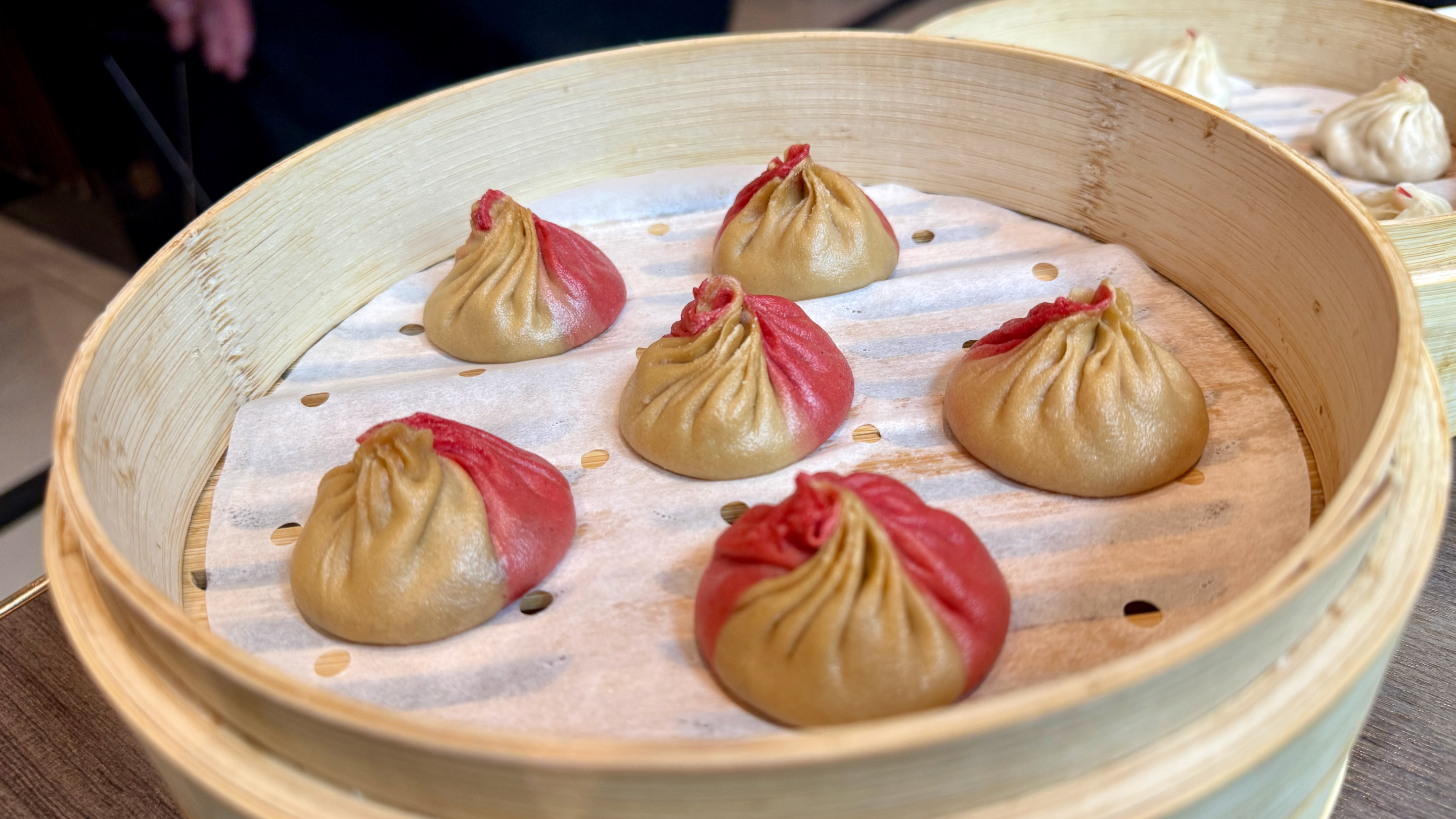 a basket of six soup dumplings