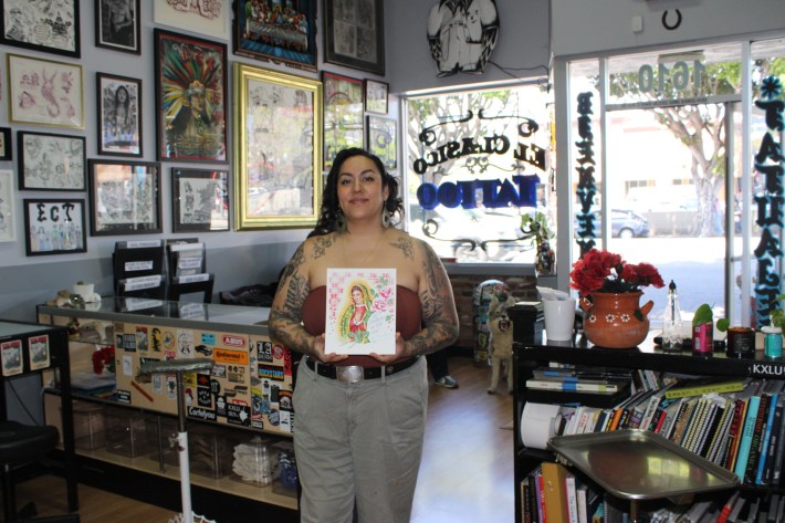 an artist holds artwork resembling the Virgin Mary