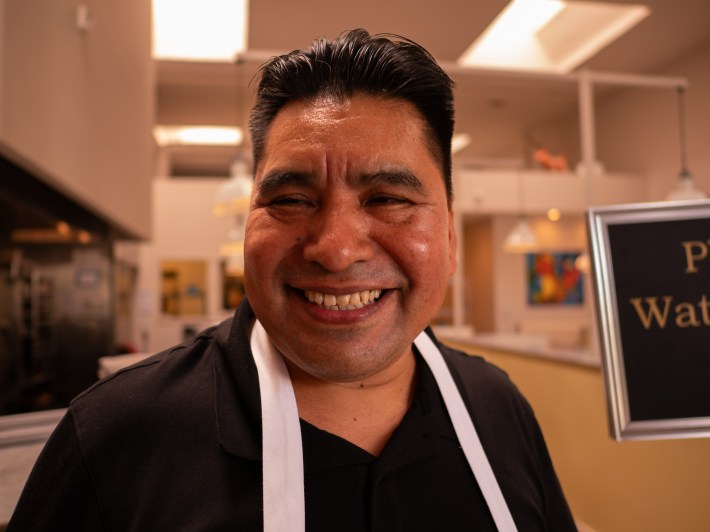 a man wearing an apron smiles