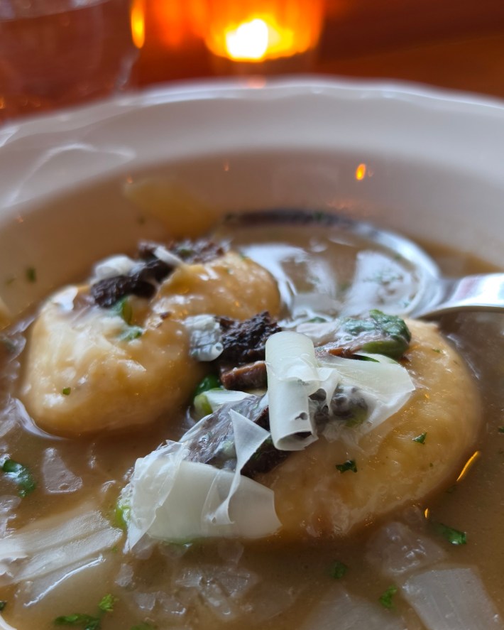 Close up of dumplings on plate with candle in background.