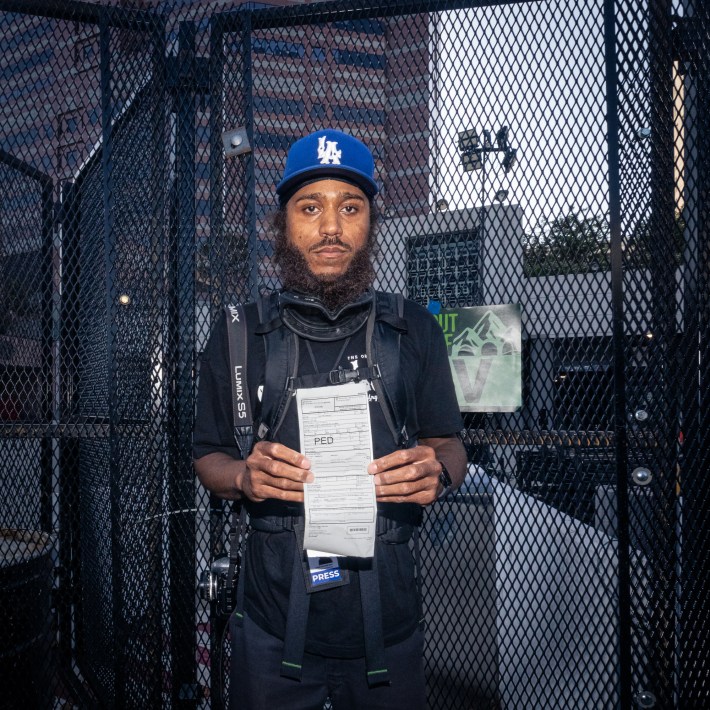 Journalist holds citation facing camera.