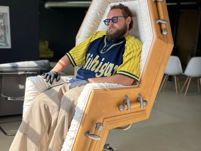 a man sits inside a coffin chair