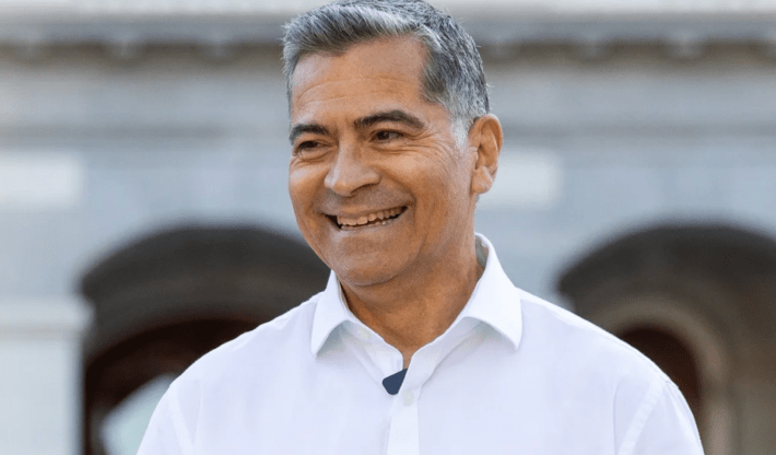 a man in a white collared shirt smiling