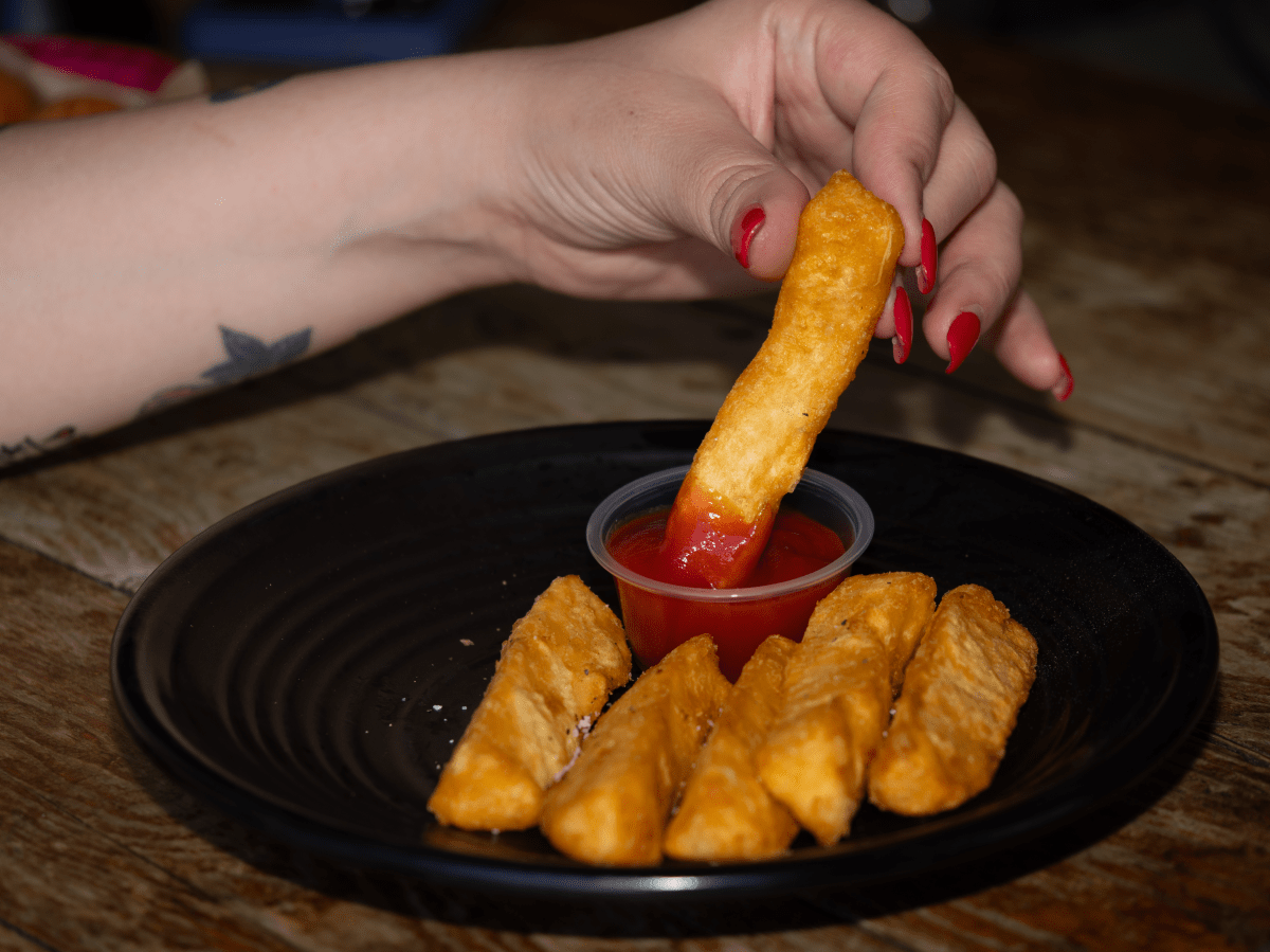 a fry being dipped into ketchup