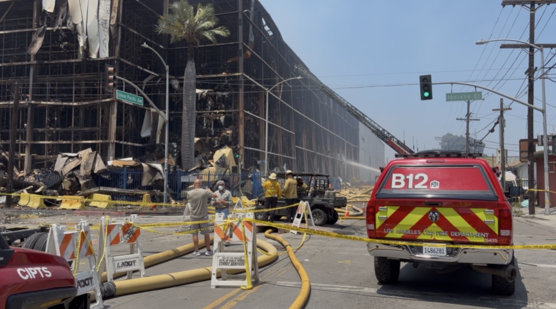 the aftermath of a fire. a fire department vehicle is in the road
