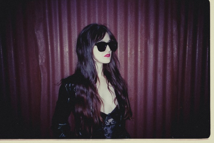 A woman with dark hair and darker sunglasses