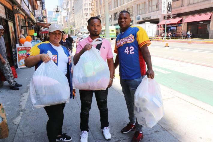 three people holding plastic bags of items