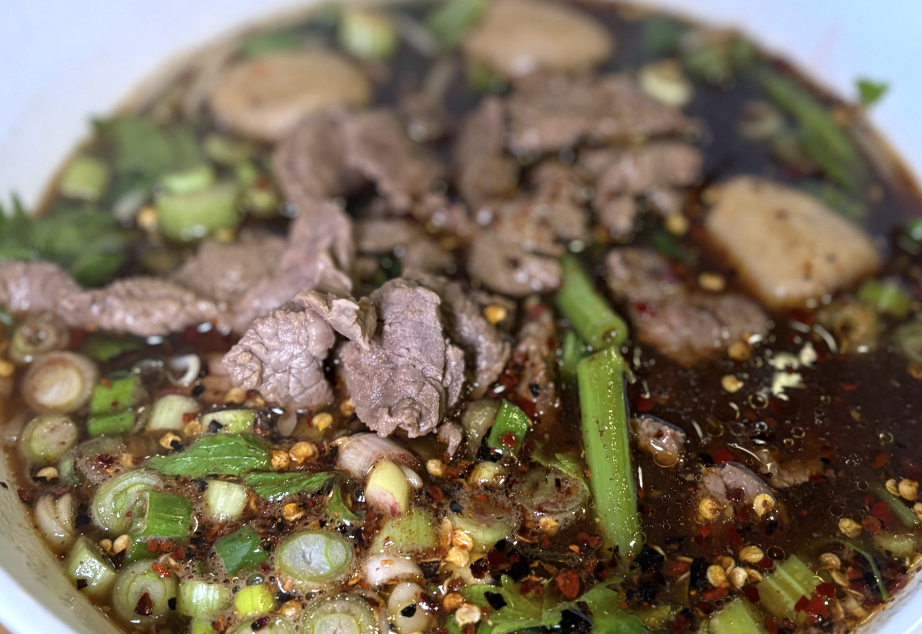 a Thai dish with beef, broth, and shallots