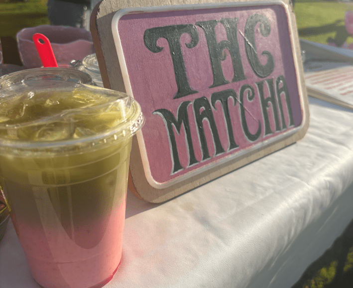 a strawberry matcha drink next to a sign that says "THC MATCHA"