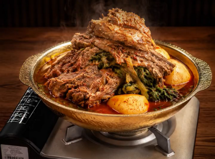 Pork neckbone hot pot with potatoes on top of a burner