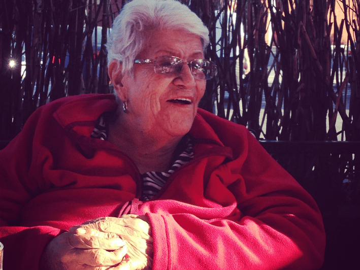 an older woman with white hair and a red jacket