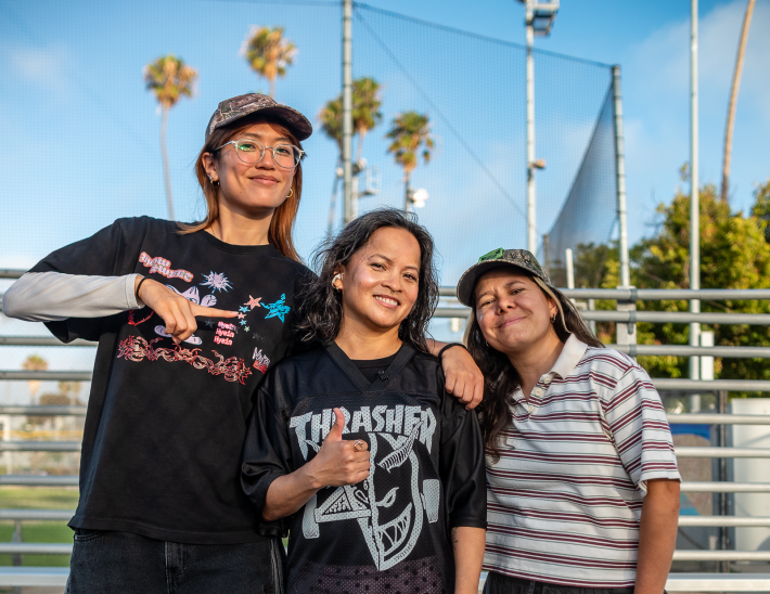 three woman skaters pose together