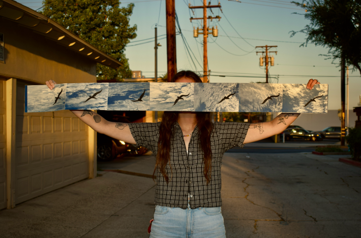 an artist with her piece 'Under the Same Sky' (2025), a cyanotype screen-printed accordion book