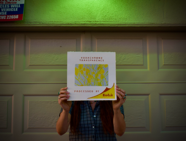 an artist holds her CMYK screen-print piece