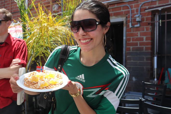 a woman in a Mexico soccer jersey poses with a waffle