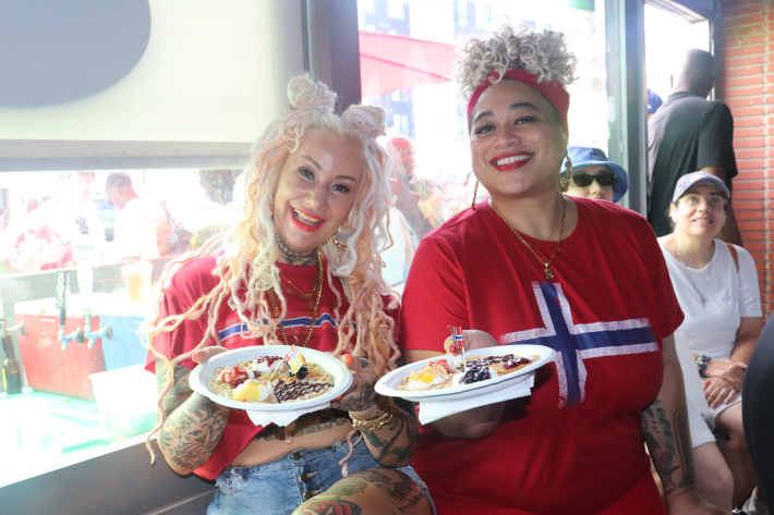 two women holding waffles and smiling