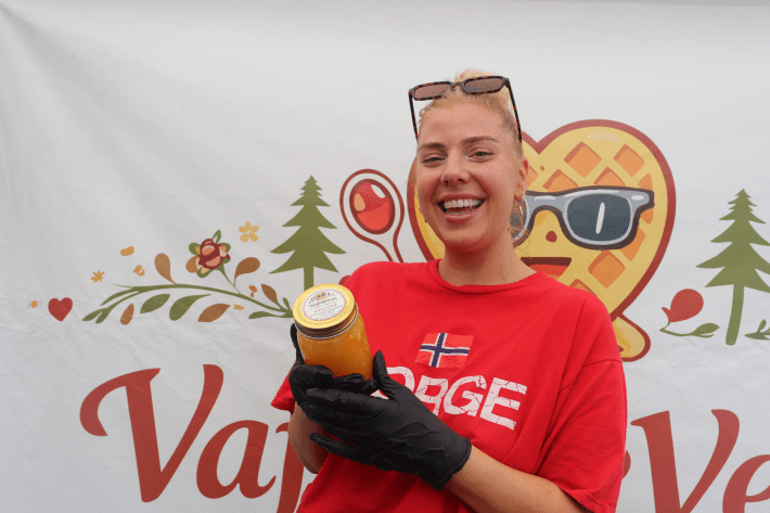 a woman holds a jar of orange jam