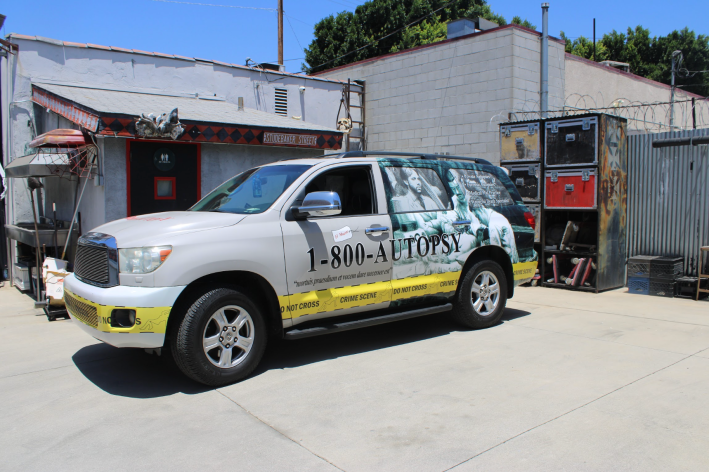 a truck that says 1-800-AUTOPSY on the side