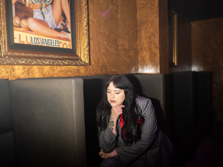 a woman with long dark hair wearing a suit