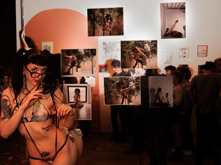 an artist in lingerie beside her art work