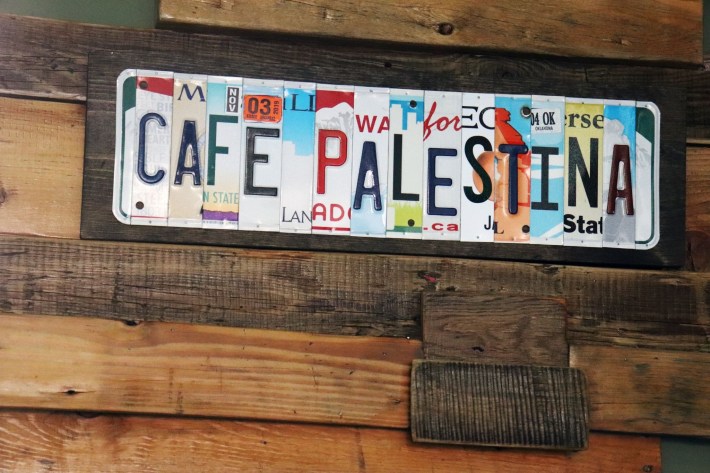 A sign made from repurposed license plates that says "CAFE PALESTINA"
