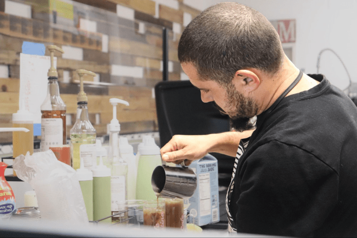 a man pours espresso over a drink