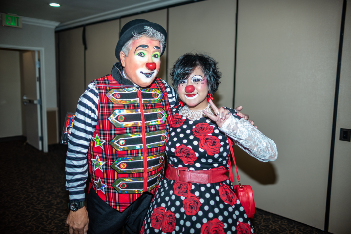 two clowns wearing red noses posing