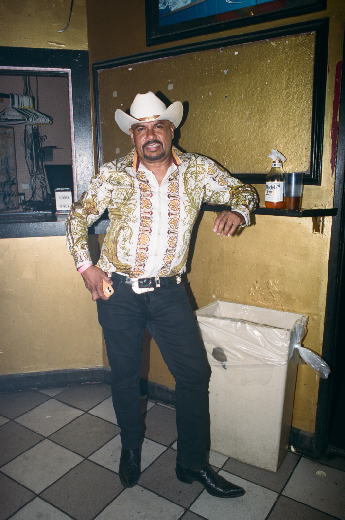 a man in a cowboy hat and printed shirt