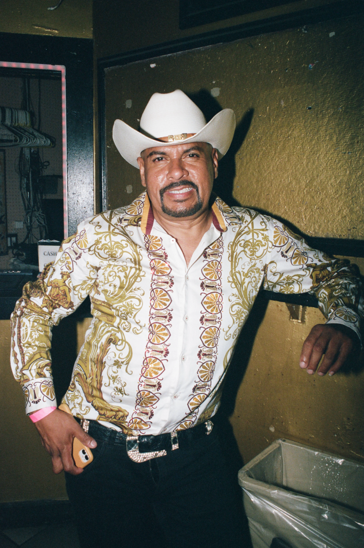 a man in a cowboy hat and printed shirt