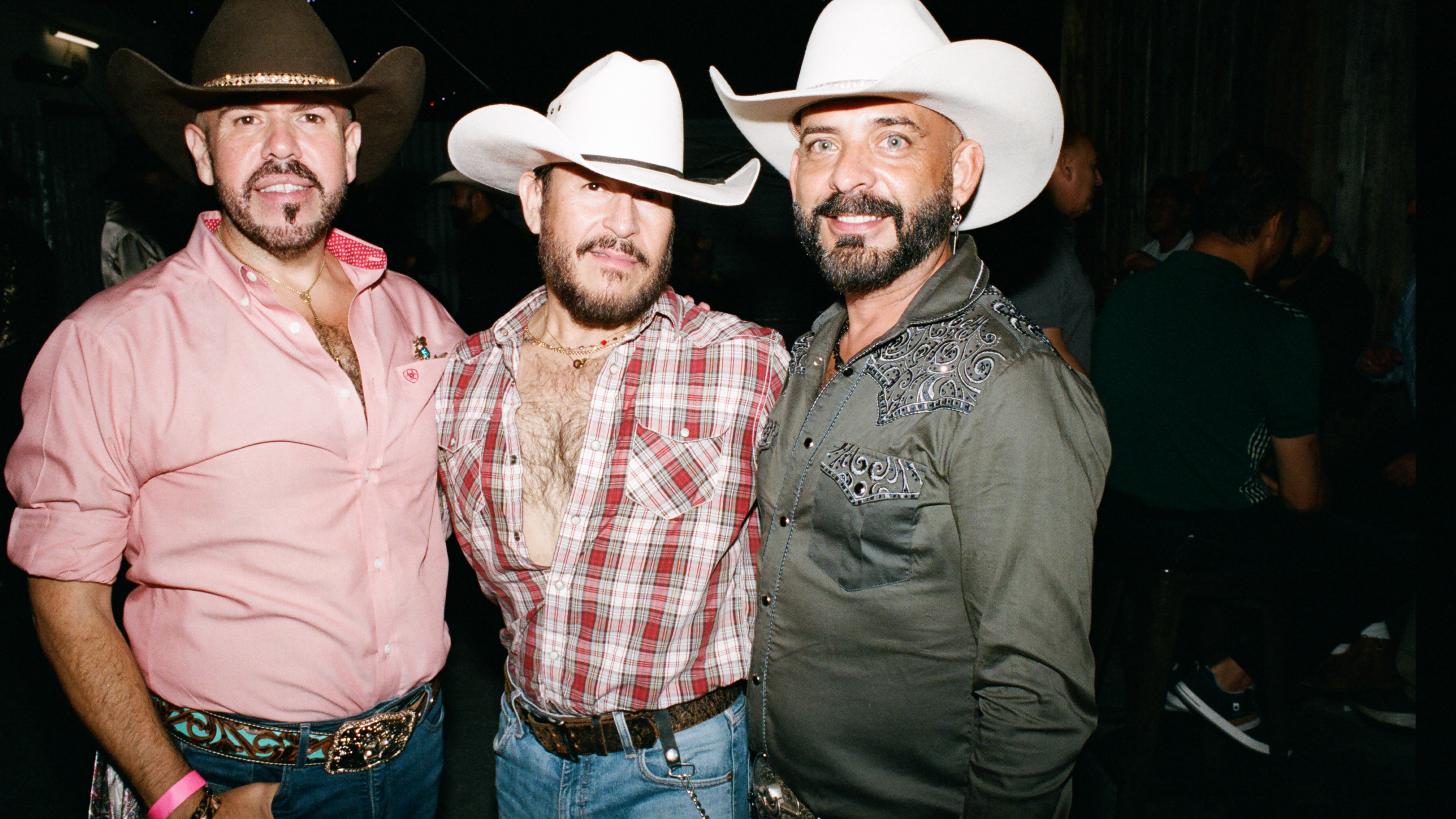 three men in cowboy hats at a bar