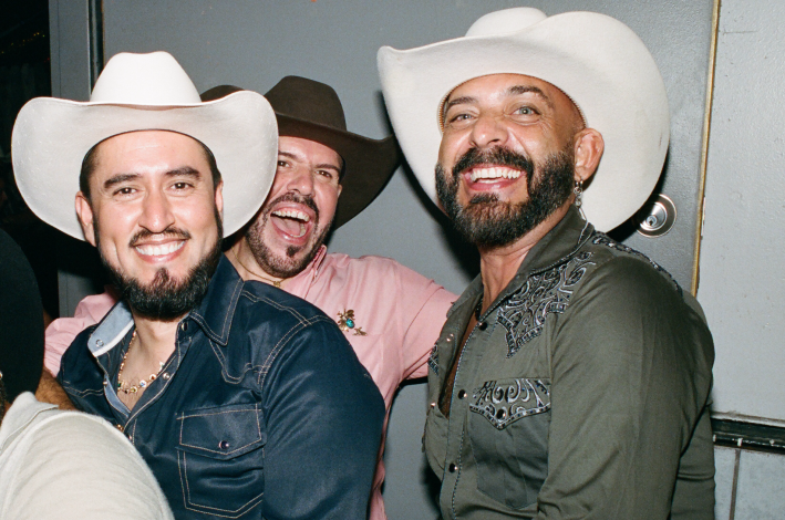 three men in cowboy hats at a bar