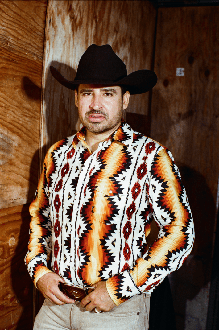 a man with a black cowboy hat and printed shirt