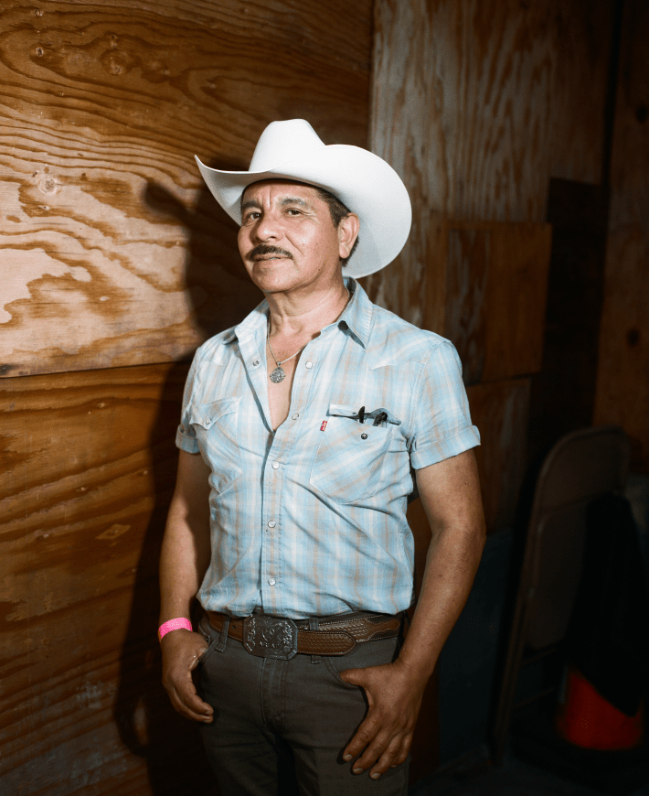 a man with a mustache and is wearing a cowboy hat