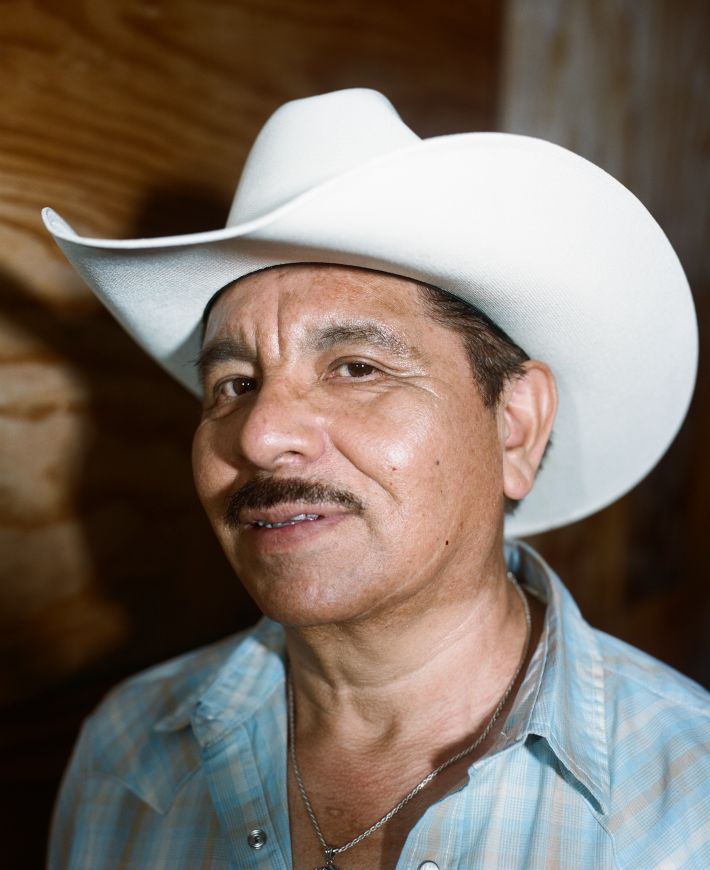 a man's portrait. he has a mustache and is wearing a cowboy hat