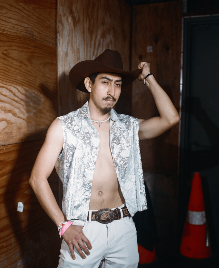 a man with a cowboy hat and vest