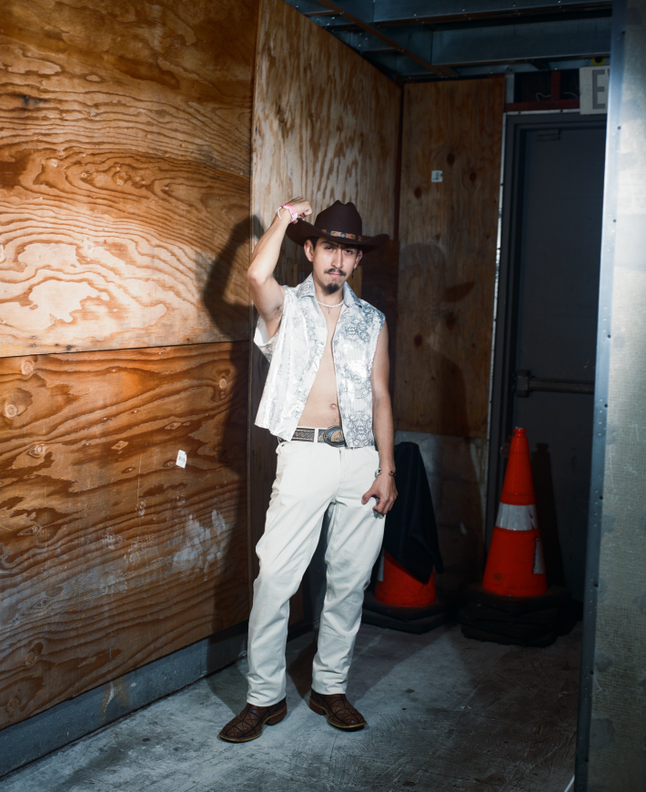 a man with a cowboy hat and vest