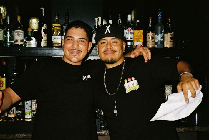 two bartenders behind the bar