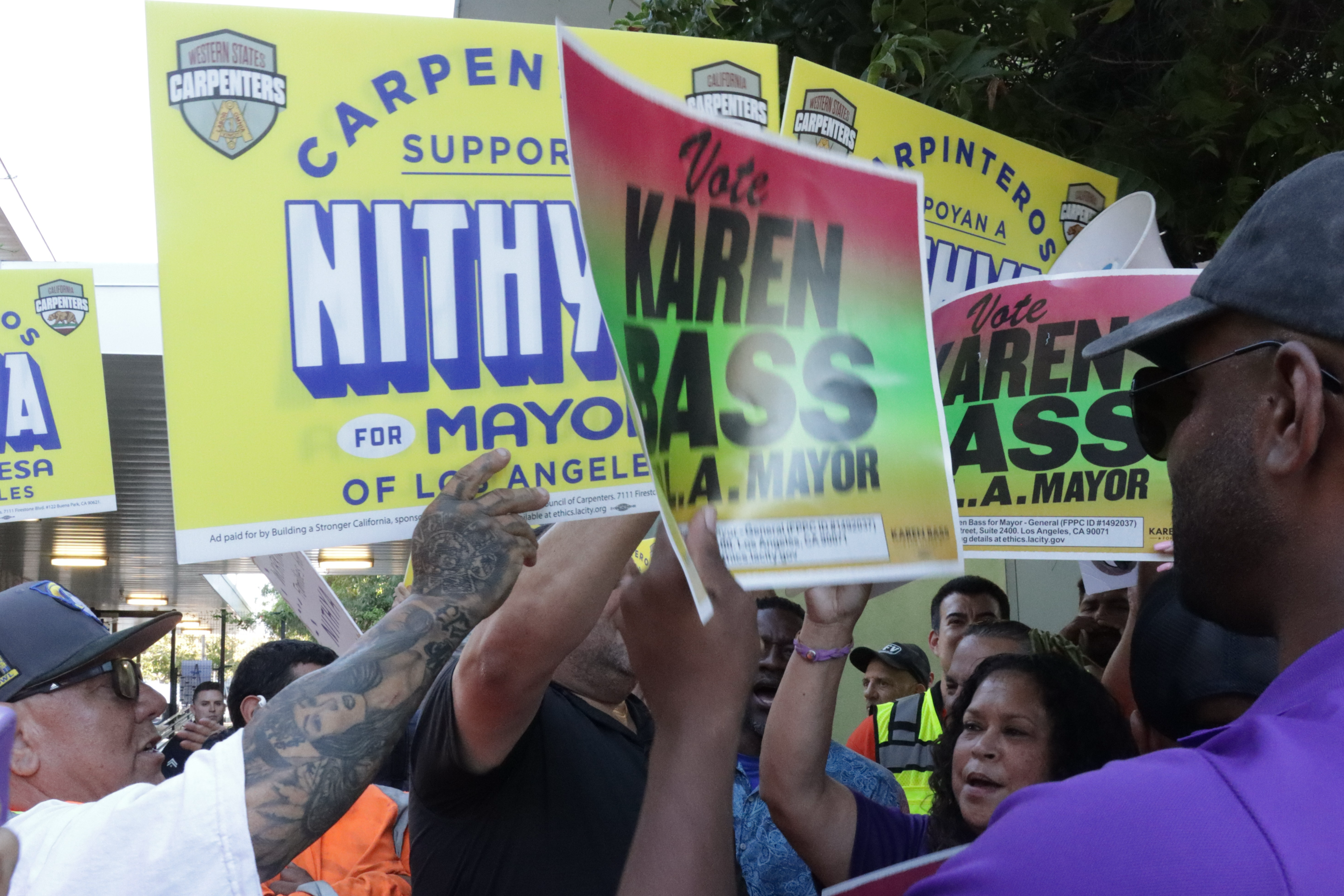The Western States Regional Carpenters Union rallies for Council member Nithya Raman next to the competing SEIU 721 rally for Mayor Karen Bass outside the Sherman Oaks East Valley Adult Center