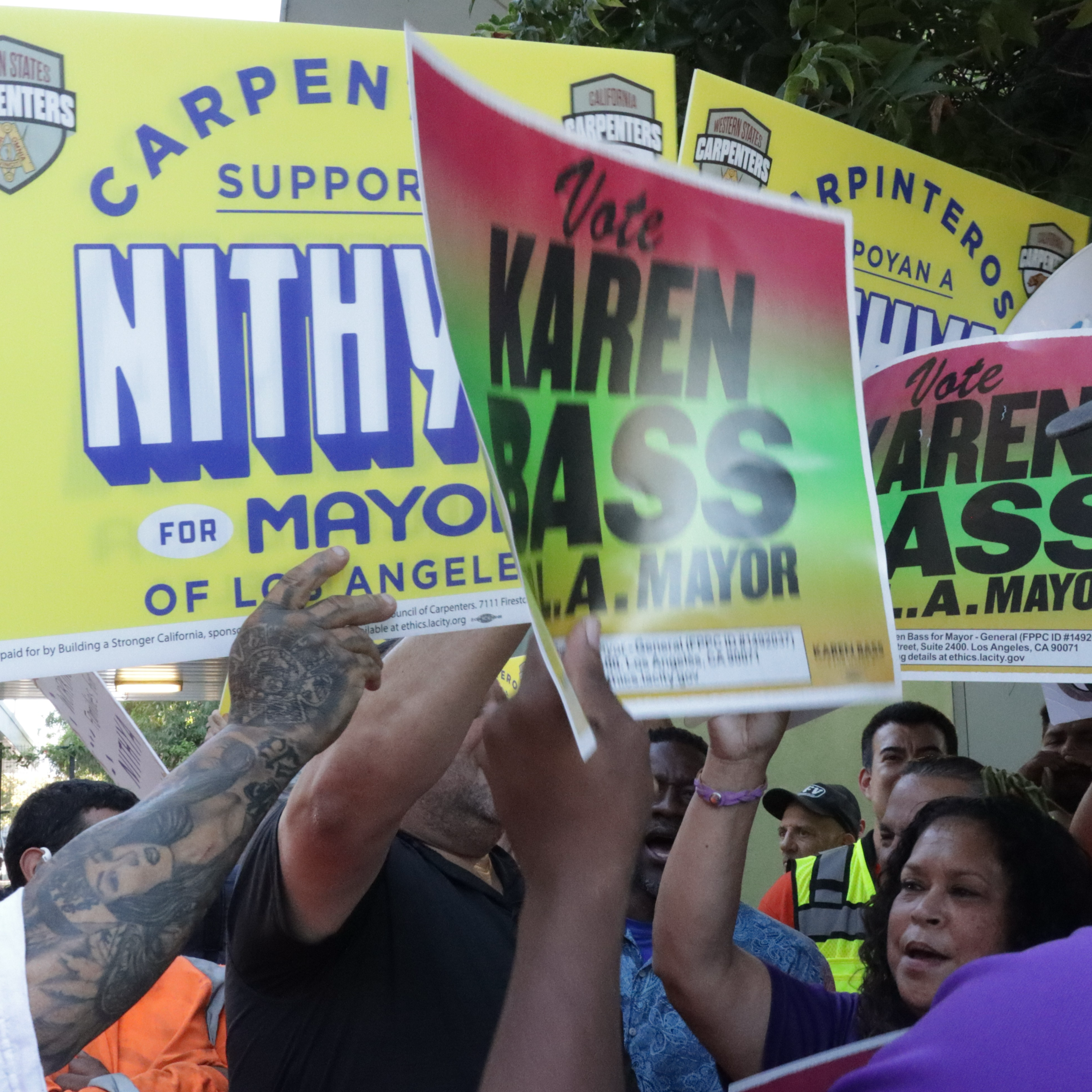 The Western States Regional Carpenters Union rallies for Council member Nithya Raman next to the competing SEIU 721 rally for Mayor Karen Bass outside the Sherman Oaks East Valley Adult Center