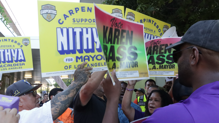 The Western States Regional Carpenters Union rallies for Council member Nithya Raman next to the competing SEIU 721 rally for Mayor Karen Bass outside the Sherman Oaks East Valley Adult Center