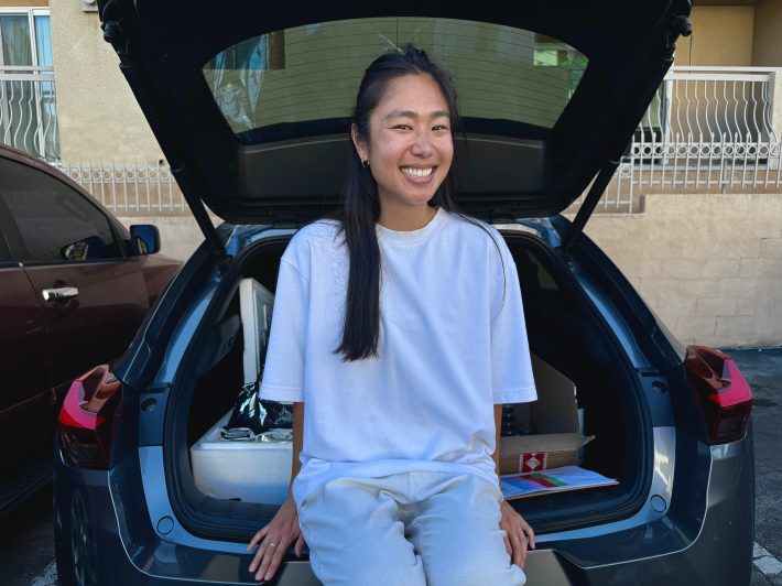a woman sits in the trunk of her car
